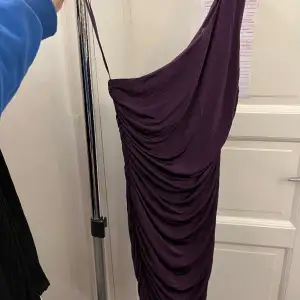 En mörk lila klänning man kan ha på fest