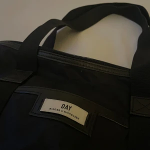 Väska från DAY - Svart väska från märket DAY, där är en liten fick där fram, ett stort fack på insidan samt 2 småflickor. Där är några smink fläckar på insidan, så därav lägre pris. Nypris cirka 550kr, mitt pris 250kr. Hör av dig om du undrar något💕 