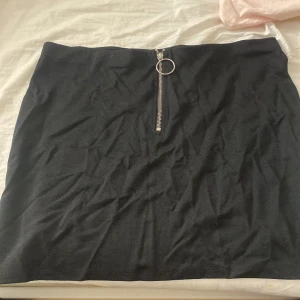 En helt oanvänd kjol - En stretchbar kjol med en kedja. Storlek L som aldrig har används (köpte den men ångrade mig eftsom den va lite stor) 