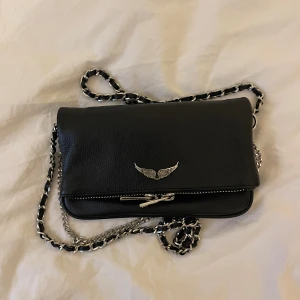 Zadig voltaire väska  - Säljer nu min jätte fina Zadig Voltaire väska pga den inte kommer till användning längre. Nypris:2745  Skick:ser ut som ny, d har ba försvunnit lite silver från själva drag löparen men det är extemt lite kan skicka bild på de det om det så önskas 