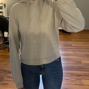 Vit/beige hoodie ifrån NA-KD - Använd men ändå fint skick, tecken på att den är använd syns i muddarna på ärmen (se bilder) 