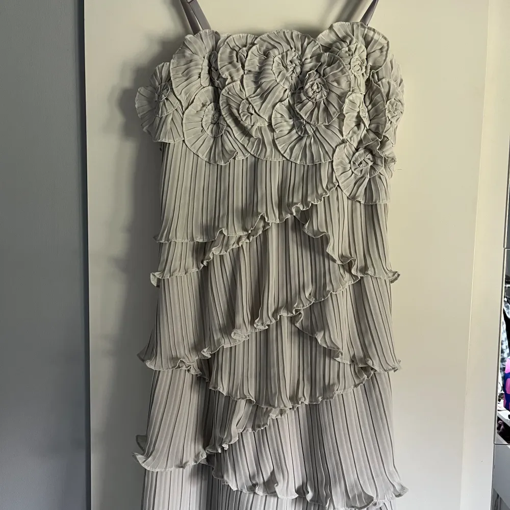 Otroligt fin klänning med volanger och fina detaljer! Går att ha exelbandslös och det finns en gömd dragkjedeja på ena sidan.🌸 ljusljus grå/vit. Klänningar.