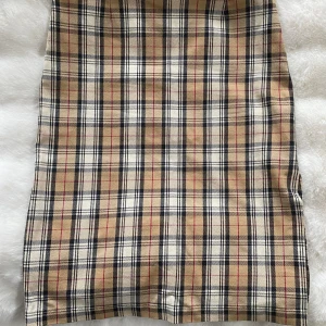 Rutig kjol i strl 38 från Sinequanone - Använd men i fint begagnat skick.  Mått Midjan: ca 37 cm Längd: ca 59 cm  95% bomull, 4% polyamid och 1% elastan  Kommer från ett djur och rökfritt hem.