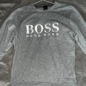 Hugo boss tröja med reflektivt tryck - Hugo boss tröja som har ett reflektivt tryck som gör att tröjan ser väldigt snygg ut om man tar bild med blixt! Passar L/M Skick 8/10