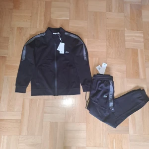 Lacost Tracksuit - En oanvänd/ny Lacoste Tracksuit säljes. Stl M på både delarna. Säljer ihop för 700kr eller separat för 400kr st.Skickas eller möts upp i Stockholm. Vid frågor är det bara att skriva.