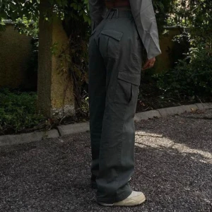 ADSGN-cargo byxor - Säljer dessa gröna cargobyxor från ADSGN. Gamla favoriter, men behöver rensa ur garderoben. Hög midja och sitter snyggt i rumpan, vida ben. Bra skick! Jag är 36cm runt höfterna och 163cm lång. 