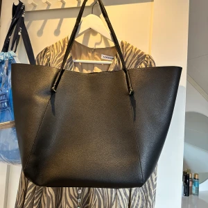 Svart väska - Svart stor väska från mango! Man får plats med väldigt mycket samtidigt som den är väldigt snygg!