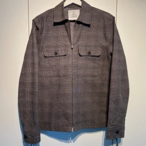 Grå Overshirt Bläck - Hej, säljer en grå zip overshirt från Bläck (MQs märke). Grym kvalite och skön passform. Funkar i alla tillfällen. Storlek S men passar även M. Nypris 1400kr. Pris kan diskuteras. Hör av dig vid intresse!