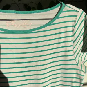 Randig T-shirt i vit och grön i storlek 14, som L. Passform: lös då jag har strl S men passar ändå bra ( som M). Skick: använt skicka. Kan bytas.