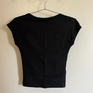 Öppen i ryggen t-shirt - Svart t-shirt, öppen i ryggen, skön, inte kommit till användning den är i bra skick kontakta om ni vill ha fler bilder hur den sitter på o om ni har några frågor osv