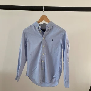 Ralph Lauren Skjorta  - Säljer denna skjortan från Ralph Lauren i fint skick men en liten fettfläck på ryggen | Storlek 14 år | Pris kan diskuteras | Hör av er vid minsta fundering!