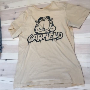 Garfield t-shirt - Säljer den här Garfield tröjan från H&M då den inte kommer till användning❣️. Den är i använt men fint skick och inga skavanker💓. Är i barn storlek 158-164 så skulle säga ungefär XS-S.