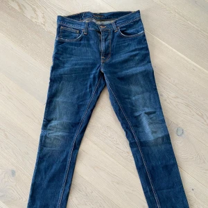 Nudie jeans 32W 32L - Säljer ett par snygga mörkblå jeans i fint använt skick. Inga defekter. 
