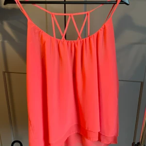 Linne/topp med fin detalj i ryggen - Linne/topp med axelband som formar ett rutmönster i ryggen. 