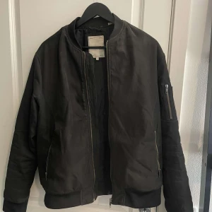 Bomberjacka Herr - Fin bomberjacka i ganska mocha aktikt tyg, funkar jätte bra på sommarkvällar o början av höst eller slutet av våren bara som den är o med tjockdröja under man kan nog ha den tills vintern.