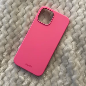 iPhone 12/12 pro skal - iPhone skal ifrån holdit för 12/12 pro. Silikonskal i färgen bright pink, nypris 199kr. Endast använt fåtal gånger, o fint skick utan defekter🎀