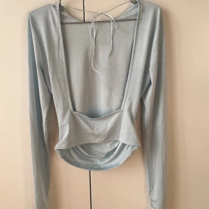 Långärmad topp - Superfin topp från Hanna Schönberg X NAKD i ljusblått med öppen rygg🦋🩵✨