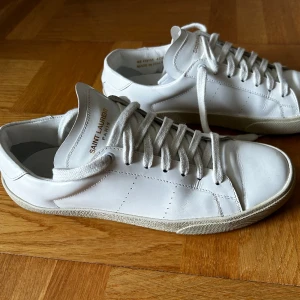Saint Laurent vita sneakers  - Vita sneakers av Saint Laurent med storlek 41,5, snören och påsar följer med. Använt ett fåtal gånger därav är de i gott skick, inga repor, skador eller fläckar. Vid frågor eller intresse är du välkommen att skicka ett meddelande  Nypris: 6 500kr