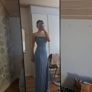 Glittrig blå balklänning - Nyskick. Aldrig använd, endast testad. Lappen sitter kvar. Tight i passform men lite stretchigt tyg.