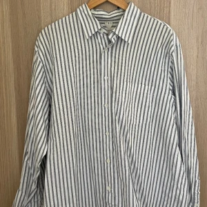 Grå-vit randig skjorta Arket - Grå-vit skjorta från Arket, bra skick, lite oversized, sitter schysst på mig som är vanligtvis L/XL! Använd fåtal gånger! 