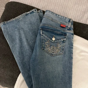 Lågmidjade jeans  - Lågmidjade blåa jeans från H&M med mönster baktill. Säljer eftersom de inte kommer till användning längre💓 är 168cm och jeansen är långa på mig. 