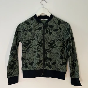 Tunn grön sport jacka barn - Passar bra nu när det börjar bli varmare. Är i storlek 134/140 och är i bra skick. Passar både tjej och kille.