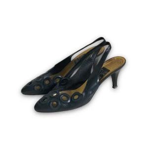Svarta pumps med slingback häl - Eleganta svarta vintage pumps med slingback häl och dekorativa hål. Skorna har en smal klack. Svart/blå.