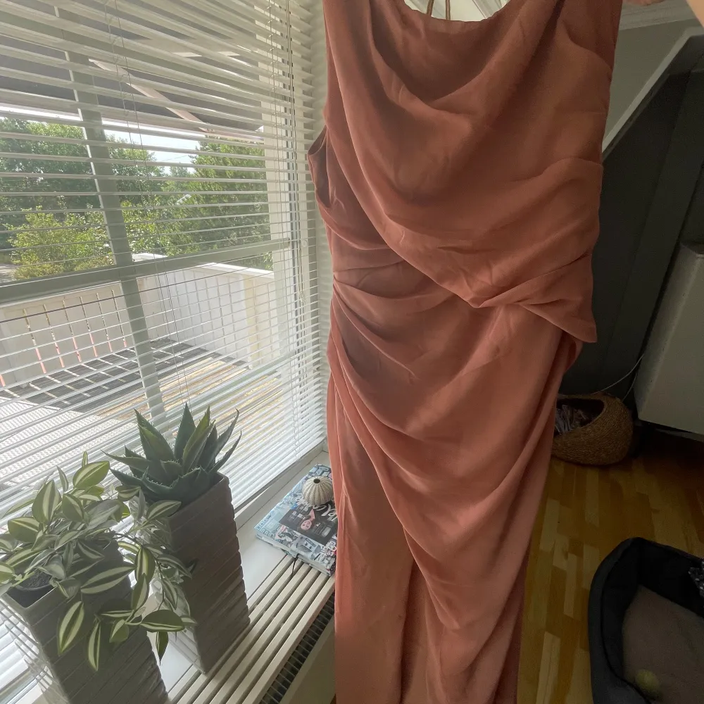 Maxiklänning i nytt skick i färgen dusty rose. Endast använd en gång. Perfekt som balklänning, brudtärneklänning eller festklänning. Ganska liten i storleken så jag är vanligtvis en 36/38 men behövde beställa den här i storlek 40.. Mekot.
