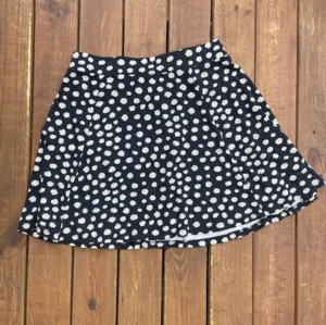 Svart kjol med blommor på! - Säljer nu min svarta kjol med vita blommor på!😊 Använd, bra skick!  Köpt från HM. Storlek M Dragkedja bak på kjolen. Pris kan diskuteras! 