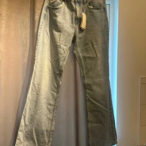 Jeans  - Jeans Strandivarius  Storlek 40 passar även strl 38 Blåa Denim Midjemått: 88cm Innerbenslängd: 84cm Mellan lågmidjade och högmidjade och dem är utsvängda