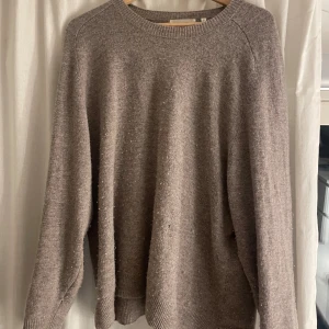 Beige stickad tröja från Carin Wester - En beige stickad tröja från Carin Wester i storlek L. Tröjan har en rund halsringning och långa ärmar. Den är varm och bekväm, men har ett litet hål som syns på närbilden. den är i äkta ull❤️