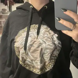 En riktigt snygg Versace hoodie med Versace tryck fram. Tröjan är storlek S men den är lite stor i storleken så skulle säga att den passar en M också. Nyskick, inga slitningar eller hål. Ej äkta💞