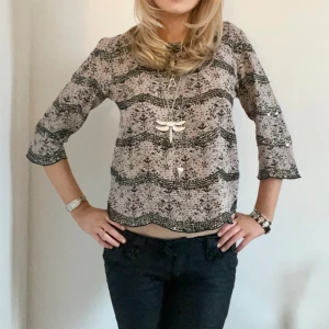 Trekvartsärmad mönstrad blus - Söt blus i rosa-blommigt mönster med paljetter! Har trekvartsärm och är i storlek 32/34. 💗