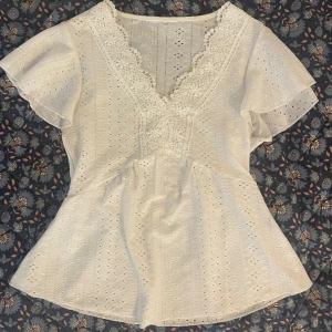Vit blus - Vit blus med fina spetsdetaljer och broderi, knappt använd o i fint skick. Står ingen storlek men passar perfekt på mig som brukar ha xs- s