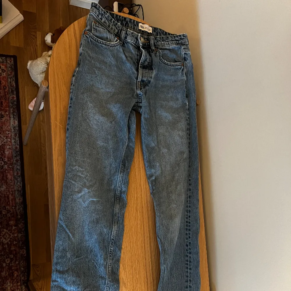 Ljusblåa jeans med slitningar längst ner. Använda ett par gånger. Mått: 80 cm i innerbenlängd, 70 mc i midja, 44 cm i lårvidd och 28 cm i fotvård! Storlek EUR 36 USA 4 MEX 26. Jeans & Byxor.
