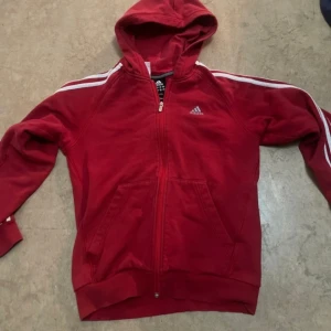 Röd Adidas kofta -  jag säljer en röd Adidas kofta i storlek L. Den är skitsnygg på och har haft på mig ett 1-2 gånger 
