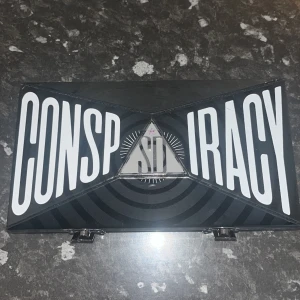 Jeffree Star Conspiracy  - Ca mått läng 21 cm, bredd 12 cm, djup 5,5. Swatchat 1-2 skuggor med ren borste, knappt synbart. Plast på spegel kvar. Inga yttre skavanker. I det hela nyskick. 