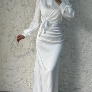 Vit klänning  - Vit satin klänning till salu! En helt ny satin klänning som är köpt för 2000kr från turkiet säljs nu pga fel storlek.. Klänningen är väldigt fin och sitter på som en smäck. Kan mötas upp eller fraktas. Skriv för frågor.Klänning ser ut precis som bild