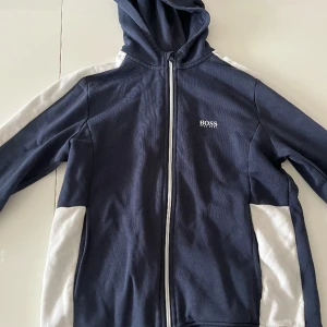 Hugo boss luvtröja  - En blå Hugo boss luvtröja i storleken XL i barnstorlek!!!. Den är i ett bra skick.