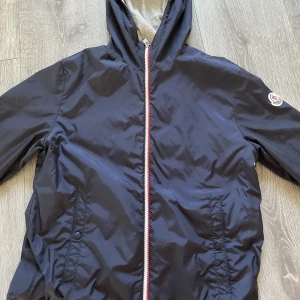 Moncler New Urville Rain Jacket - Säljer nu denna trendiga moncler windbreaker. Perfekt till våren. Jackan är i storlek 14Y. Som ungefär passar till ungefär 163+. Ingår kvitto dustbag och ett brev Använd få gånger. Hör av er vid minsta fundering 