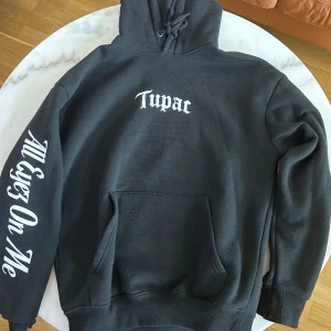Tupac hoodie  - Tupac hoodie i storlek XS från pull and bear. Köptes för cirka 2 år sedan men har inte kommit mycket till användning så den är fortfarande i bra skick. Tror inte att den tillverkas längre med det här trycket så den är sällsynt.