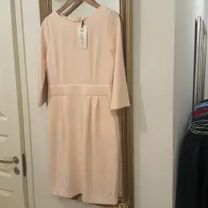 Söt figursmickrande rosa klänning med fickor i sidorna, dragkedja och rosett baktill. NYpris 399  , etikett kvar🎀