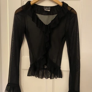 Mesh blus med volang - Sjukt söt liten blus med volang i mesh! Kan användas som en liten bolero över ett linne💕💕  Verkligen superfin men för liten för mig tyvärr. Köpt vintage från 90-talet!