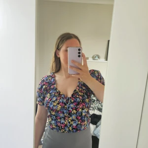 Sommartopp - Blommig sommartopp från Gina tricot i storlek XS, med små svarta knappar längst fram🦋 Använd endast ett fåtal gånger, då den blivit för liten för mig☀️Klicka på köpknappen vid intresse eller skriv till mig💗