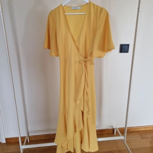 Gul omlottklänning - Gul omlottklänning i storlek 38. Märke Carin Wester. Använd 3 gånger. Fint skick. 