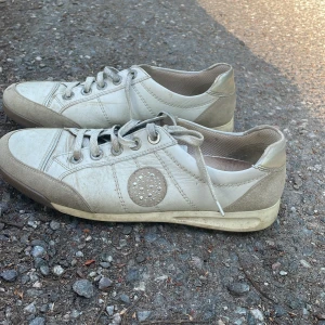 Jättesnygga guldiga skor - Snygga guldiga och vita skor. Rätt så använda. Köpt här på Plick så vet tyvärr inte märke. Perfekt nu till sommaren👌☀️