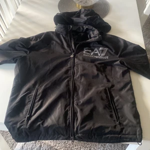 Armani jacka - Hej säljer min Armani jacka som är i fint skick den är storlek xl men passar även L och den går att använda med och utan luva för luvan går att gömmas i kragen och hör gärna av er vid funderingar 