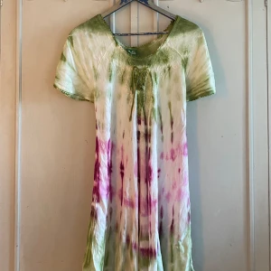 Tie-Dye Klänning  - Bohemisk tie-dye klänning i grönt och rosa. Saknar storlek men skulle säga att den passar S-L beroende på hur en vill att den ska sitta. Så fin och i bra skick men säljer för att den tyvärr inte kommer till användning. 