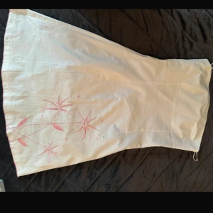 Vit klänning  - Vit klänning med gulliga rosa detaljer! Både blommor och paljetter med rosa små detaljer längst ner!💗 Märket heter Jane Norman 