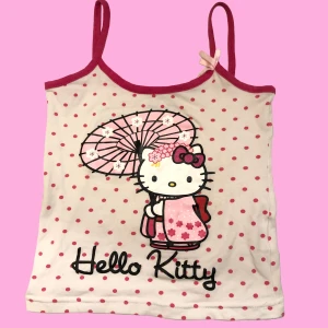 Hello Kitty Linne - Jättegulligt prickigt Hello Kitty linne!! storlek 116 men passar nog någon som har XS eller mindre! Materialet är stretchigt (bomull). Jag brukar ha S i vanliga fall. Det blir som en crop top🩷 Hör gärna av dig vid frågor!